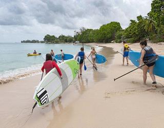Walking on the beach with surfboards in Barbados ()