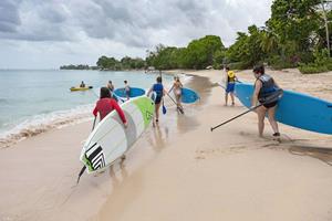 Walking on the beach with surfboards in Barbados ()